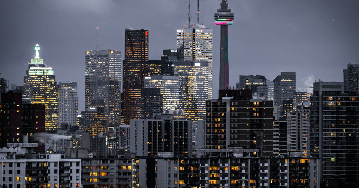 Modern glass high-rise tower with mixed commercial and residential floors against an urban skyline